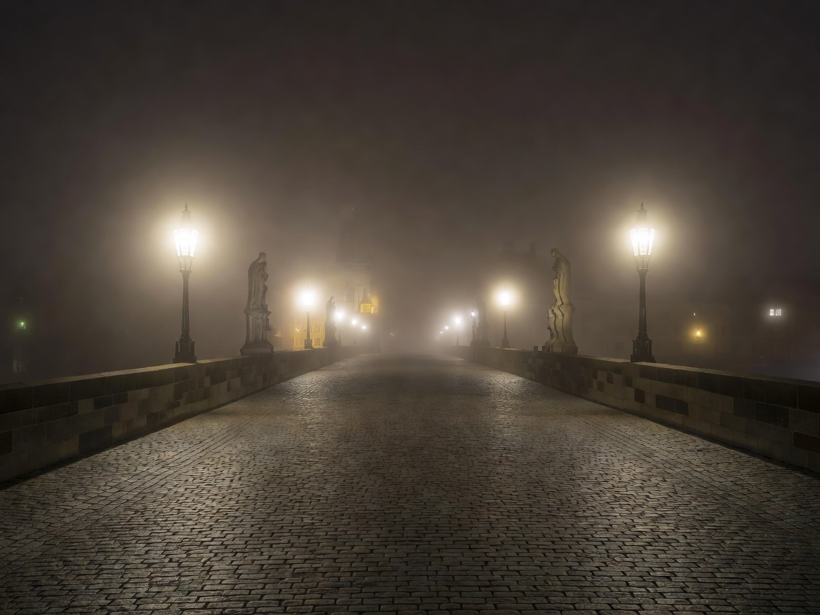 Charles bridge at night with misty gas lamps and empty cobblestones